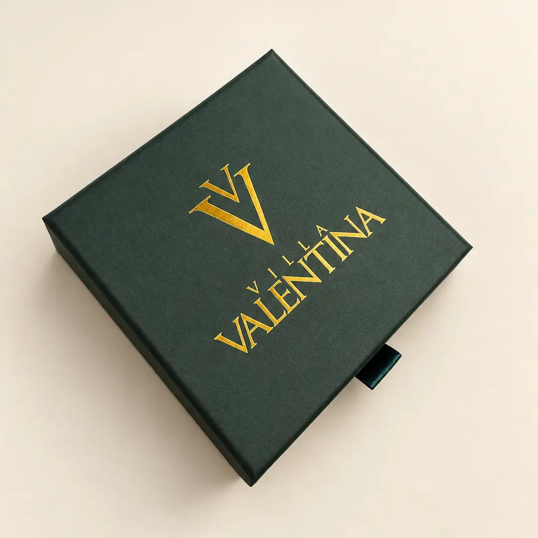 A dark forest green rectangular box with gold foil branding reading 'VALENTINA' and a large 'V' logo, photographed on a light beige background.