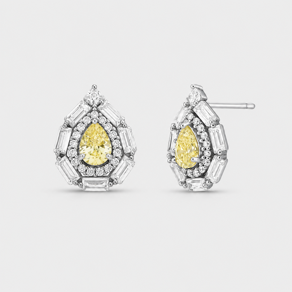 A pair of pear-cut yellow diamond halo stud earrings in silver-tone metal, surrounded by baguette and round clear stones, shown on a light gray background.