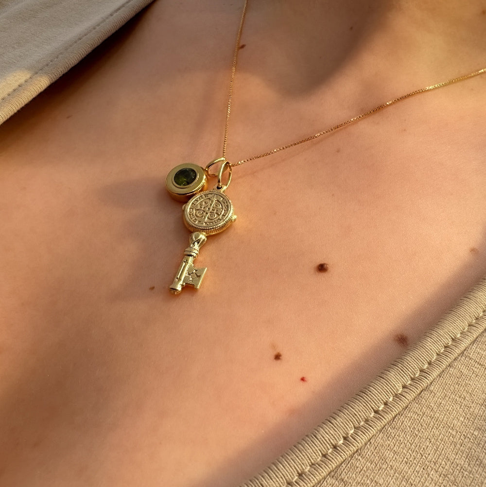 Gold necklace with a pendant on a person's neck