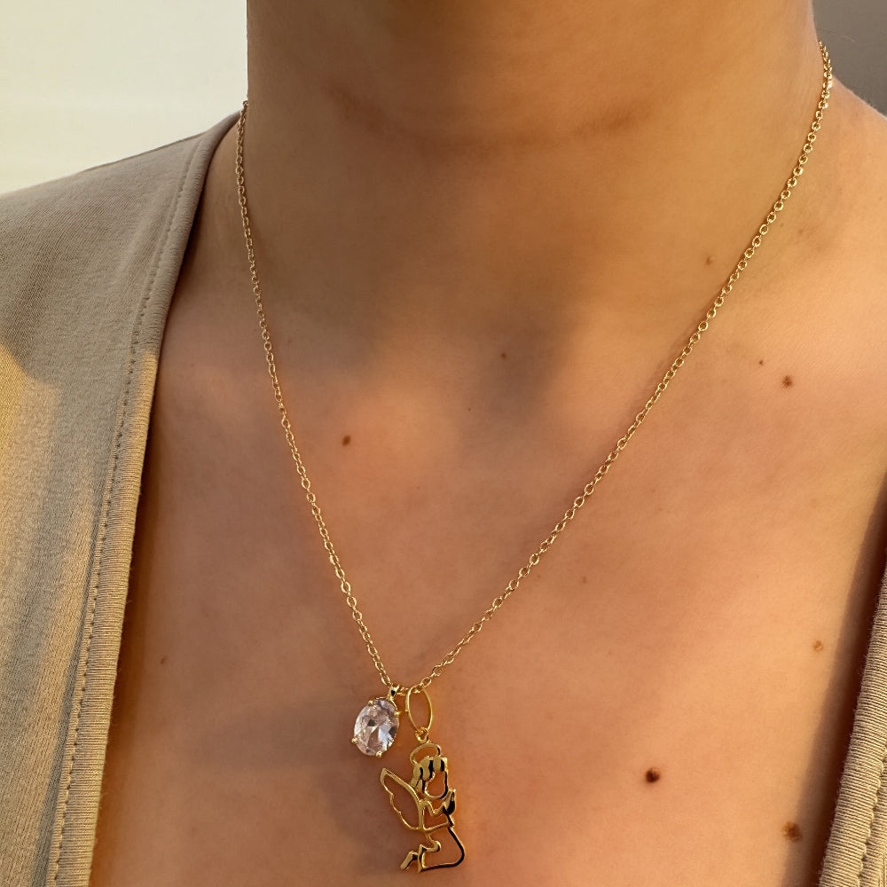 Gold necklace with a pendant worn by a person