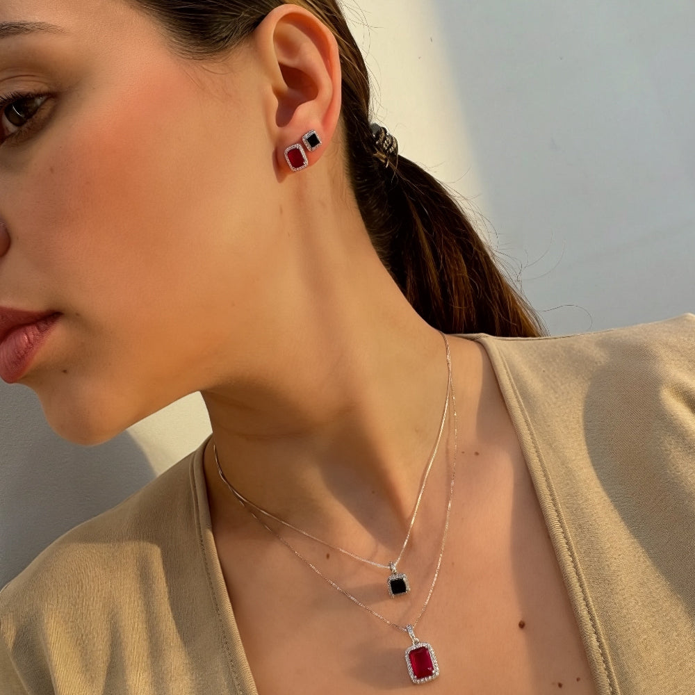 Woman wearing a necklace and earrings with a neutral background