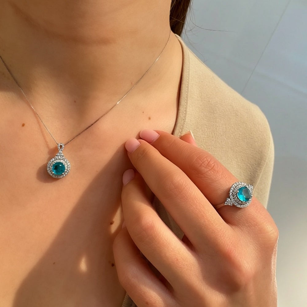Necklace and ring with blue gemstones worn by a person