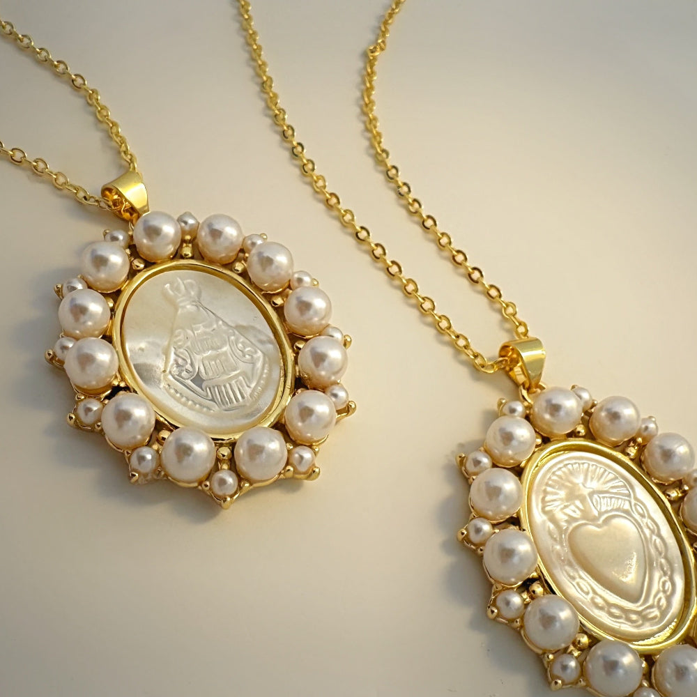 Two gold necklaces with pearl accents on a light background