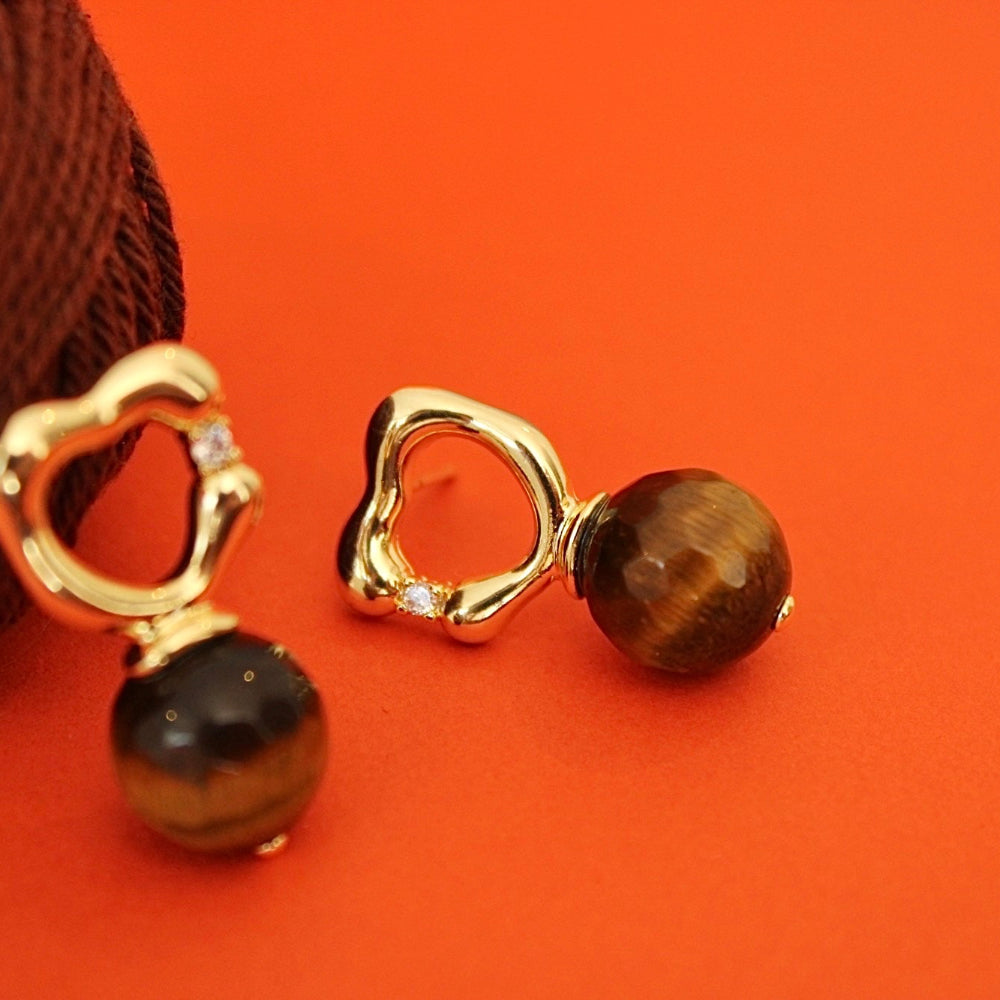 A pair of gold shaped organic earrings with tiger's eye beads natural stones.