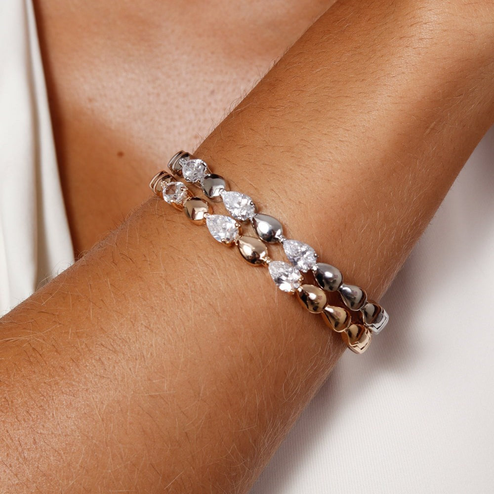 Bracelet with rose gold and silver beads on a wrist against a neutral background