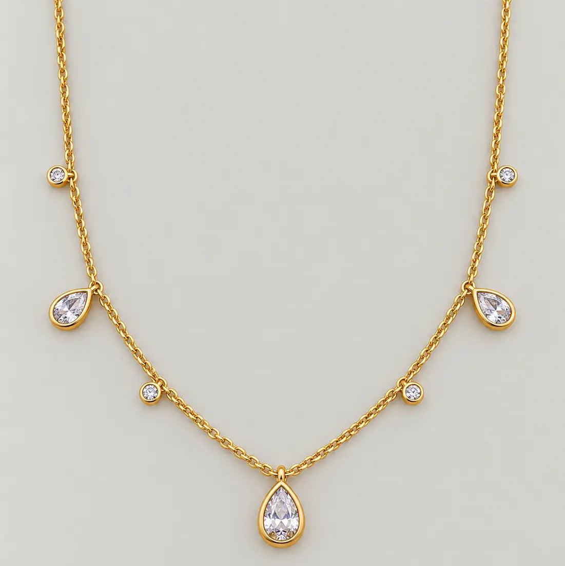 18ct gold-plated brass necklace with three clear teardrop cubic zirconia charms and four round bezel-set zirconia accents