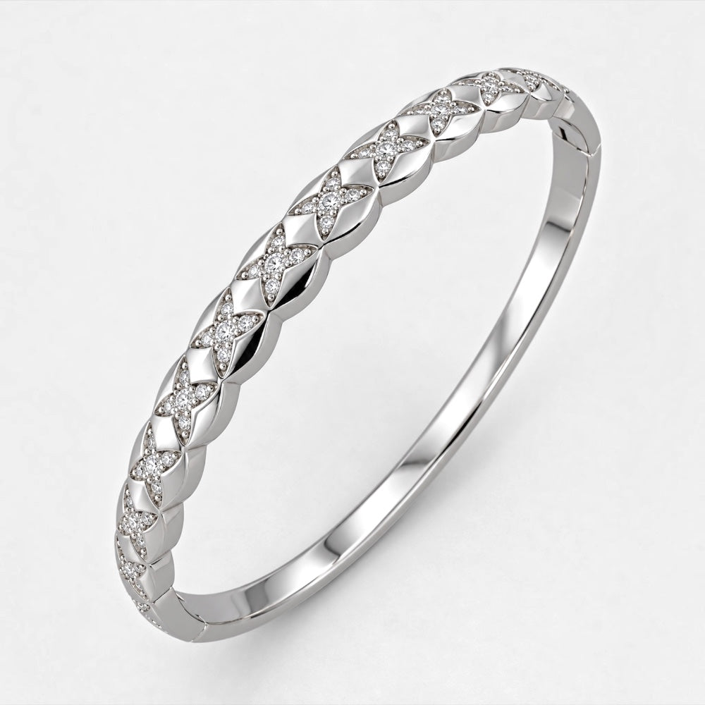 Silver-plated brass bangle with repeating geometric motifs detailed with clear cubic zirconia
