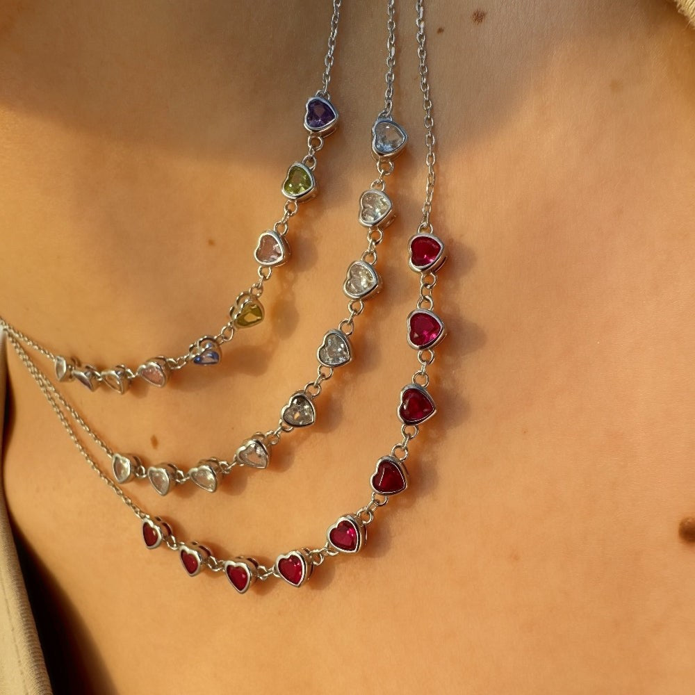Necklace with heart-shaped gemstones on a person's neck