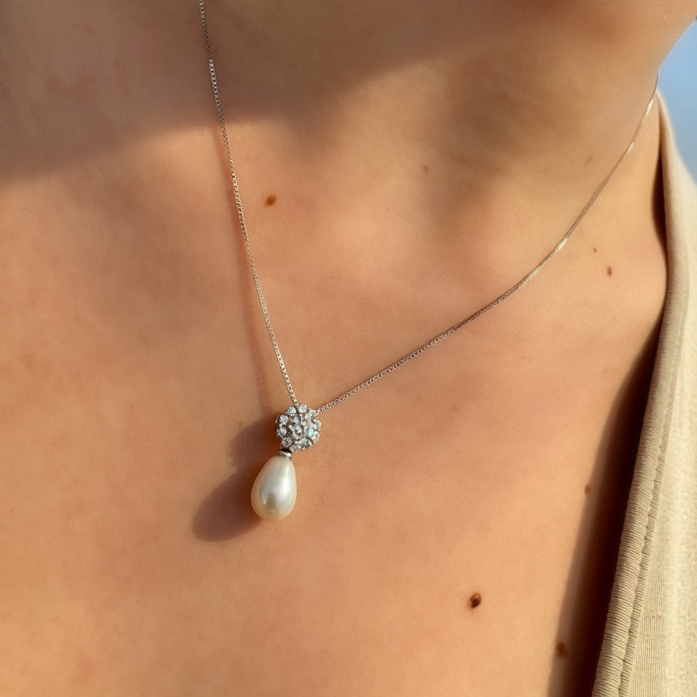 Pearl necklace with a silver chain on a person's neck
