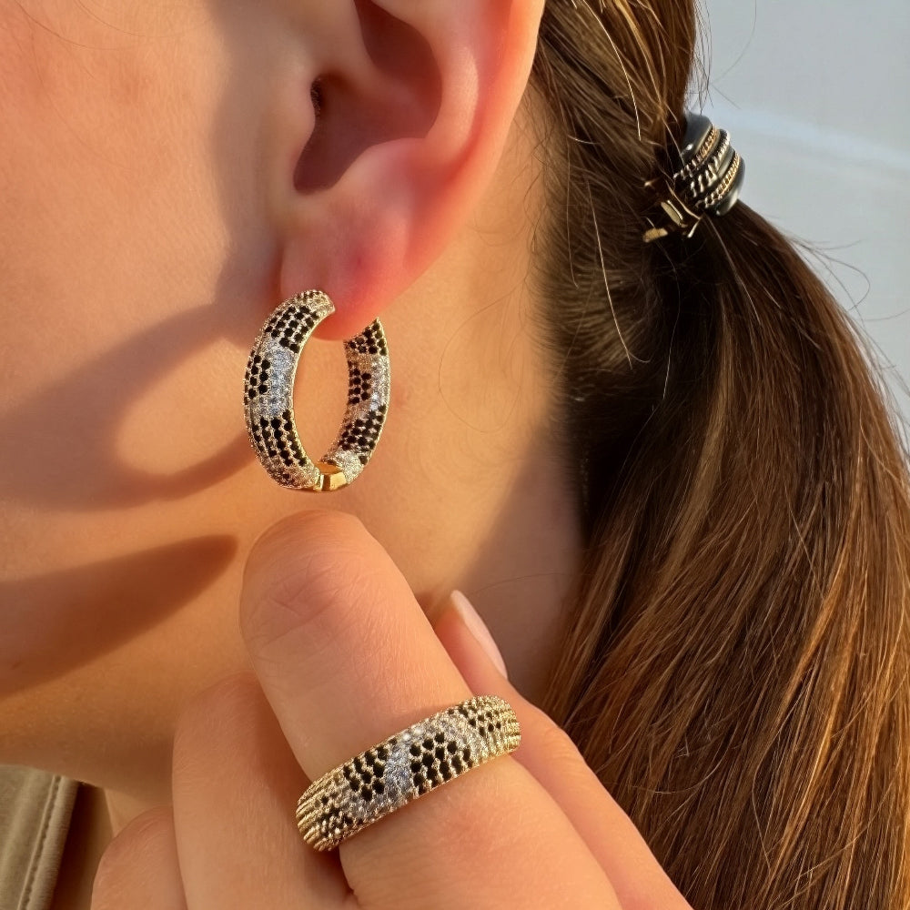 Close-up of a person wearing a hoop earring with a blurred background