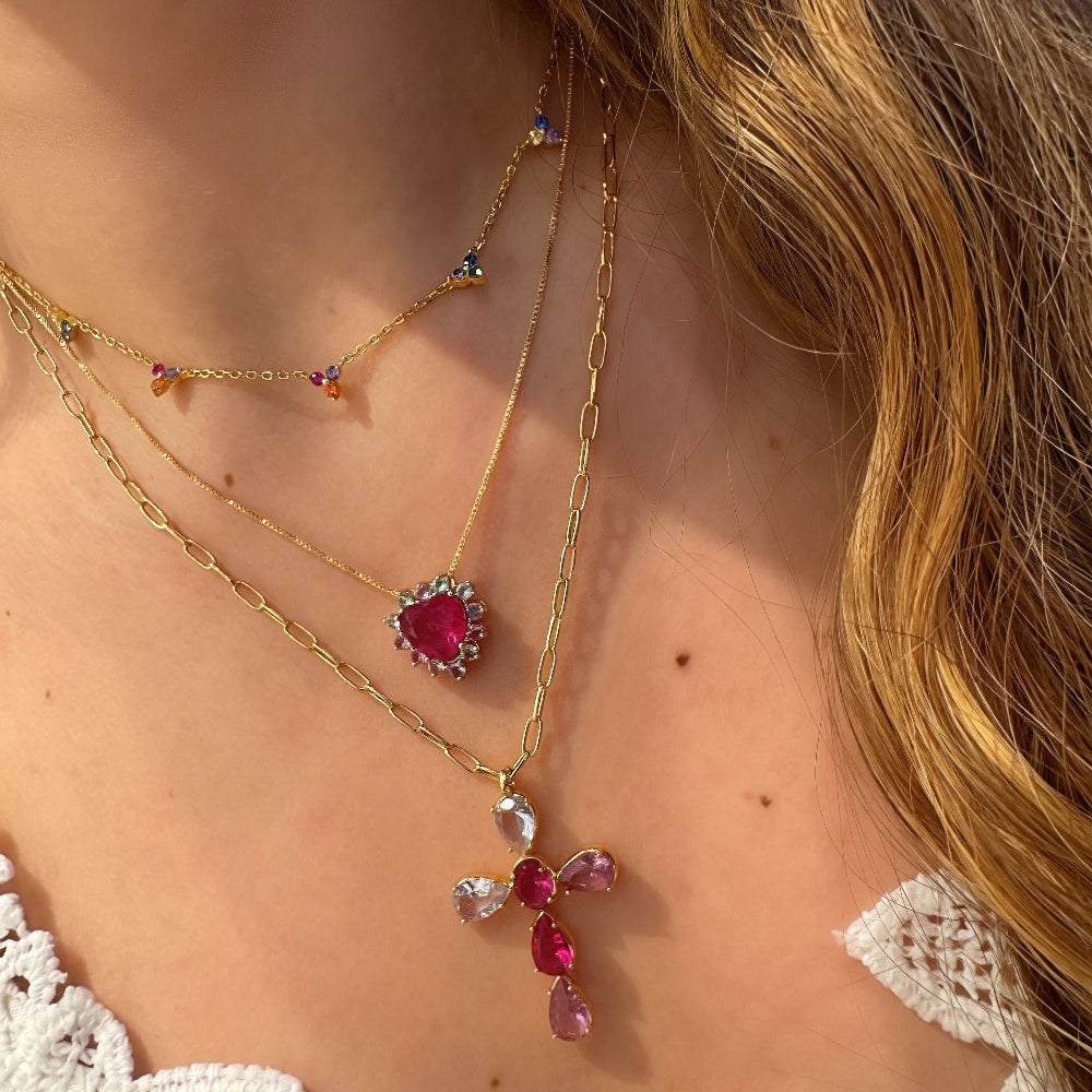 Close-up of a person wearing multiple necklaces with gemstone pendants.