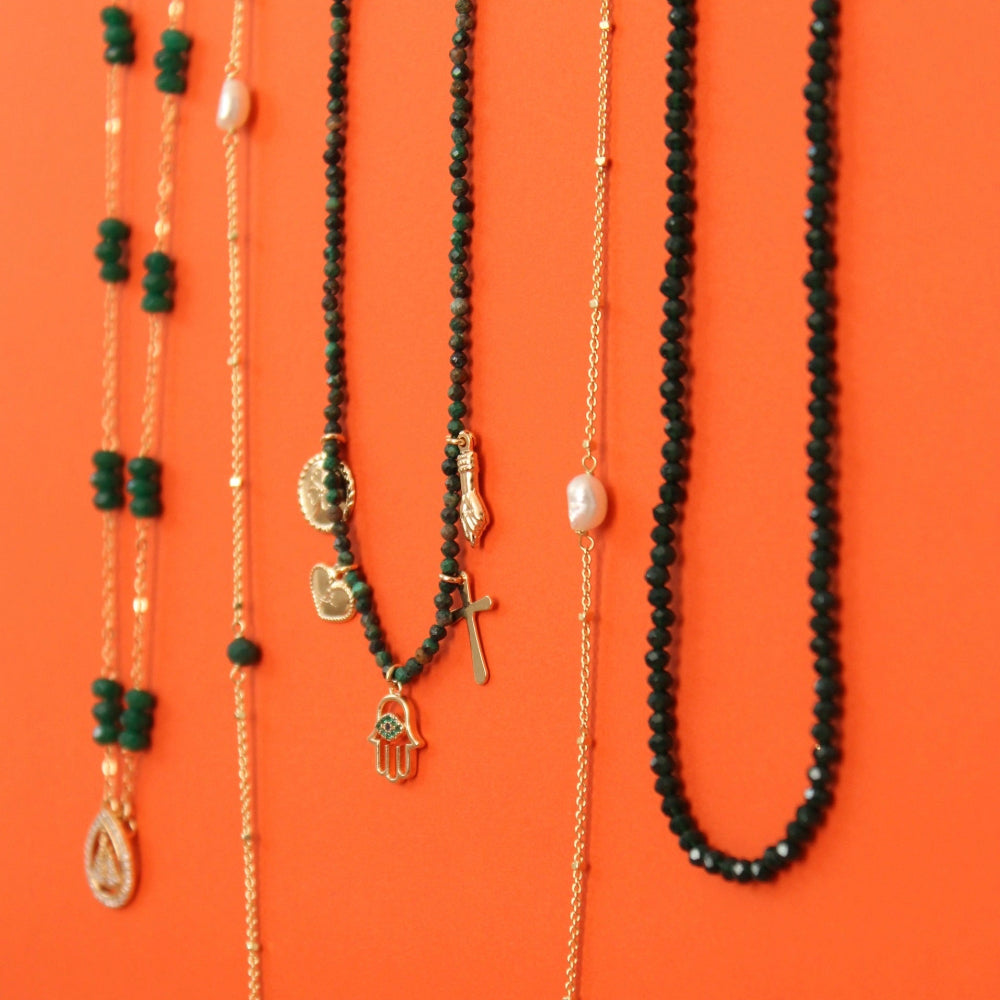Hand made necklaces with gold plated and natural stones, pearls, and small charms including a Hamsa hand and cross.