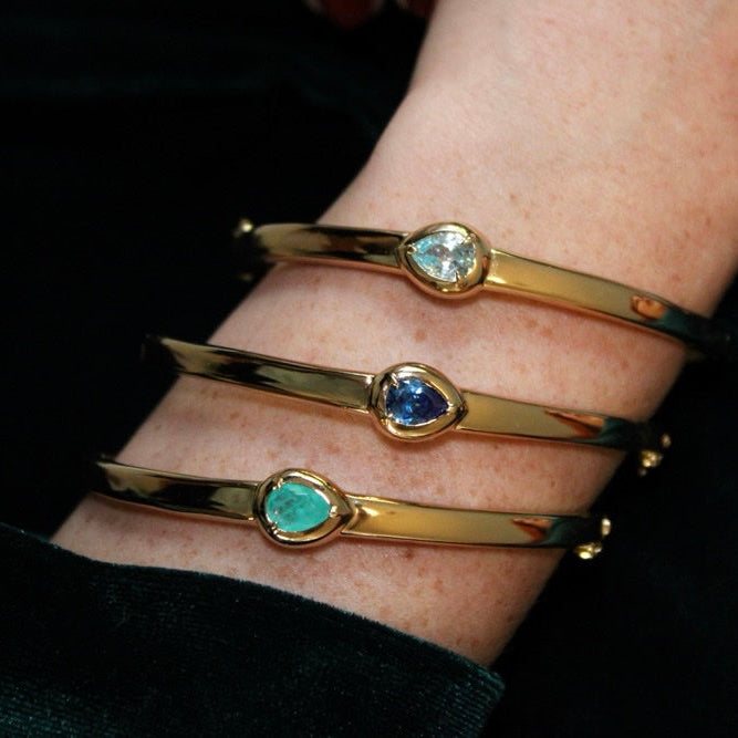 gold bangle with teardrop-shaped gemstone settings, birthstones bangle.