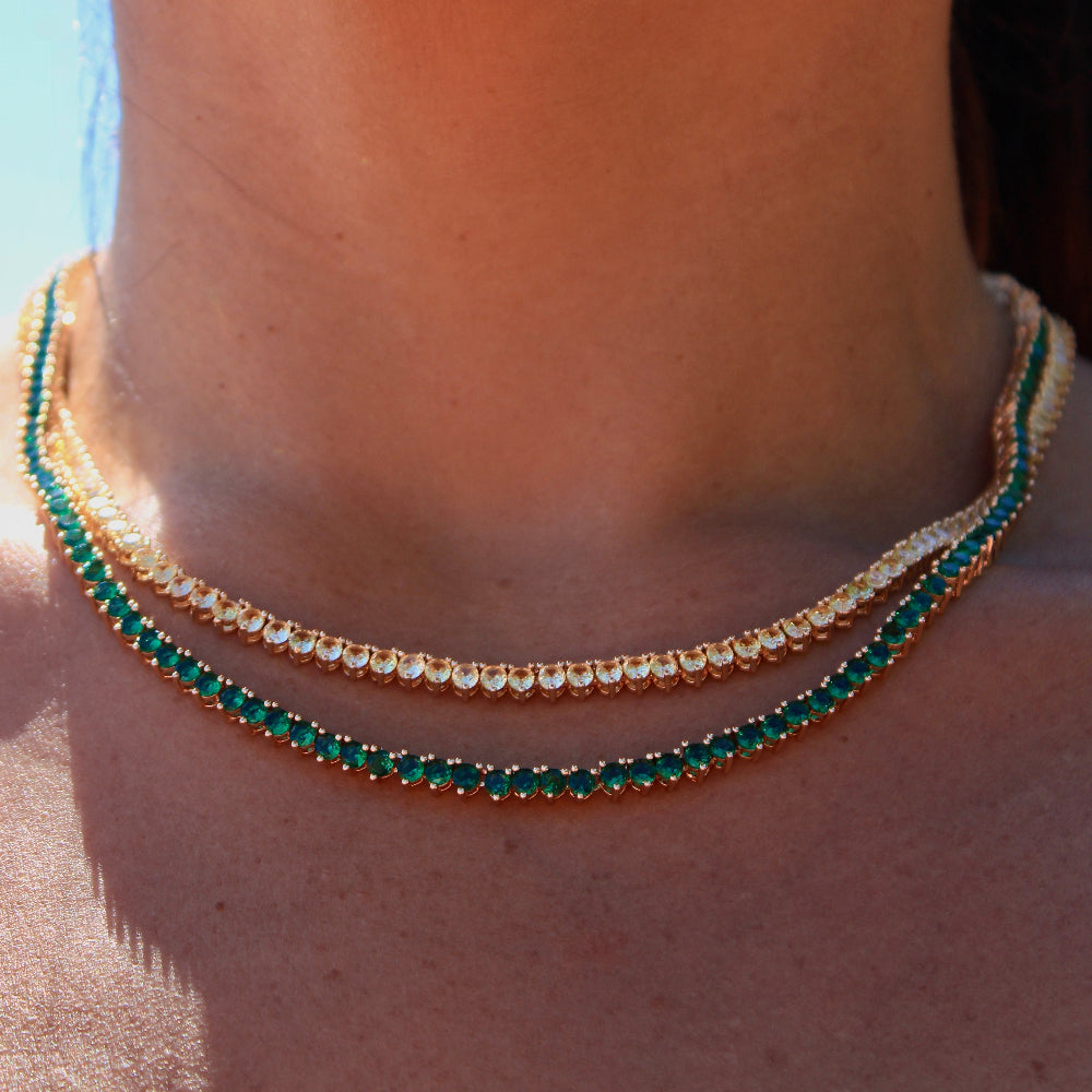 Close-up of a person wearing two necklaces with a blurred background