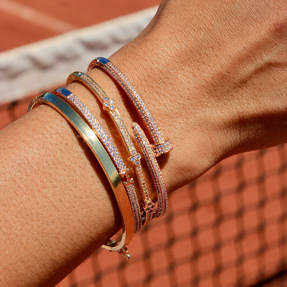 Close-up of a wrist wearing multiple bracelets on a tennis court background