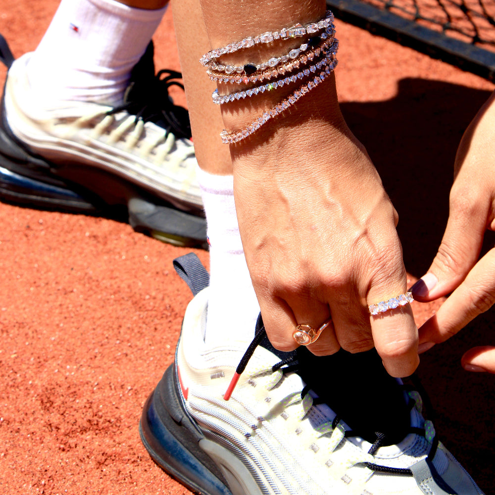 Person tying shoelaces on a tennis court