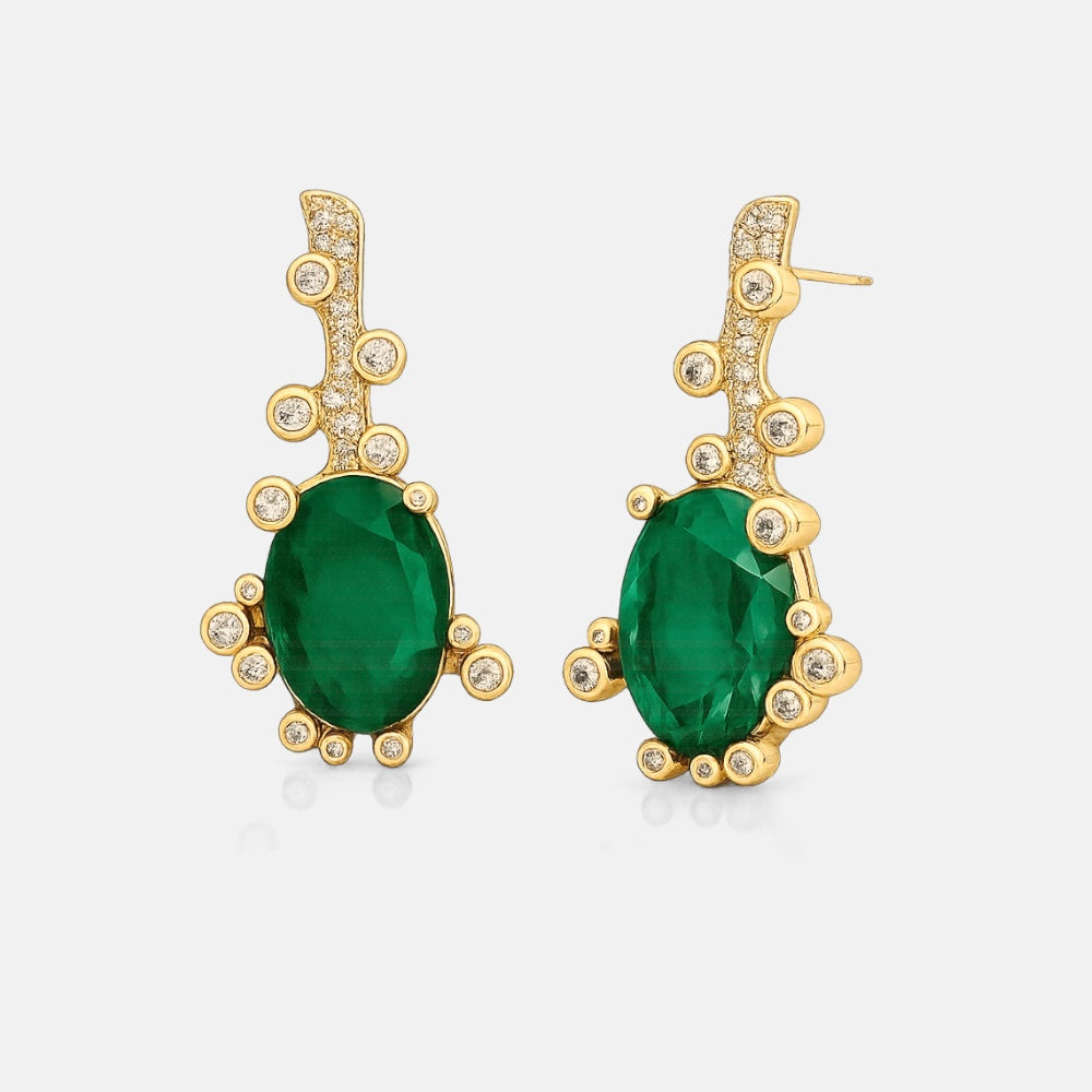 Gold earrings with green gemstones on a white background