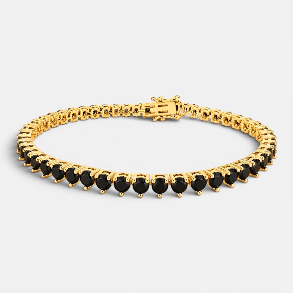 Gold bracelet with black stones on a light gray background