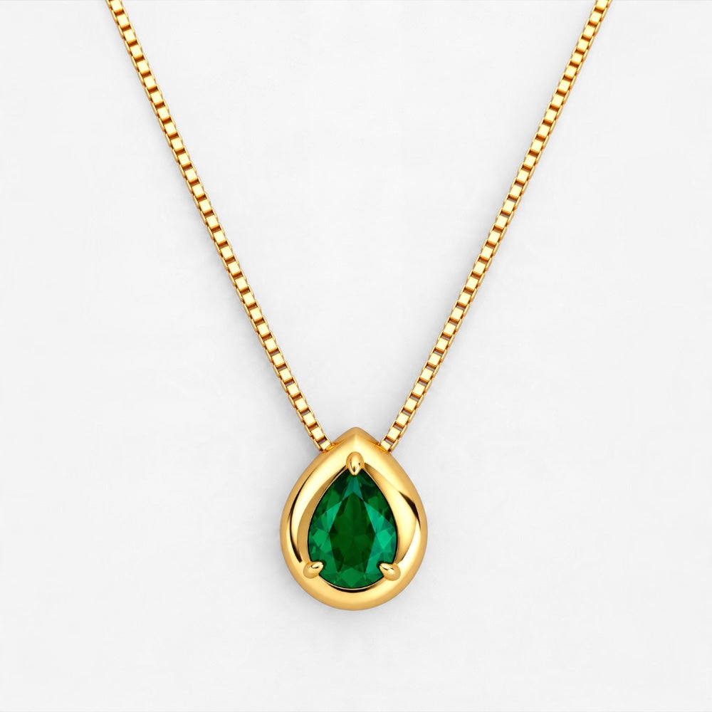 A gold pendant necklace featuring a teardrop-shaped green, suspended from a gold box chain against a clean white background.