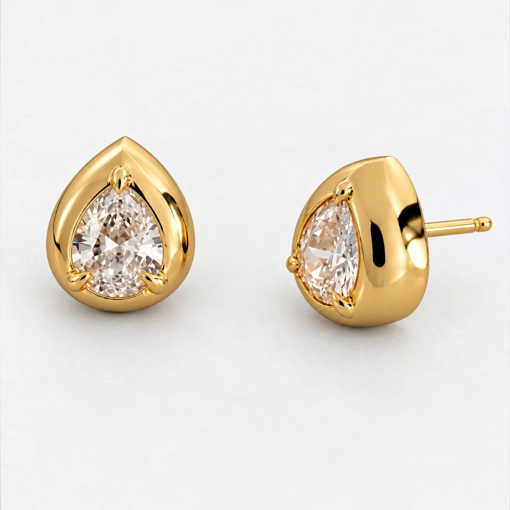 A pair of gold teardrop stud earrings with pear-cut clear gemstones, shown on a clean white background. One earring is facing forward, and the other is turned to show the post and back.