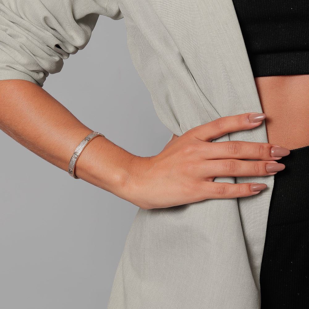 Person wearing a light gray blazer over a black top on a gray background