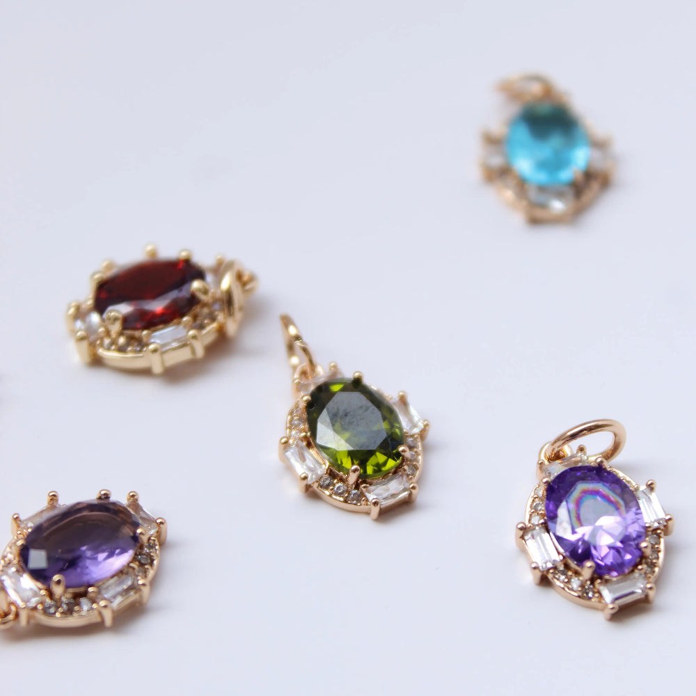 Gold earrings with colorful gemstones on a white background