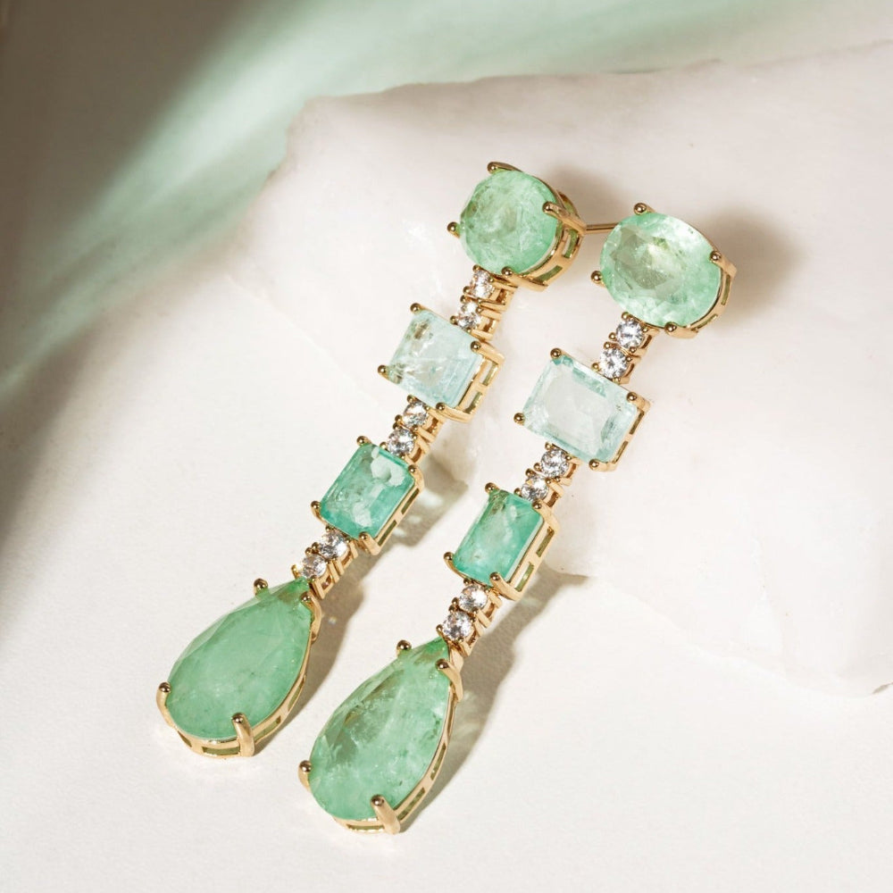 Long gold-tone earrings with pale green faceted round, rectangular and pear-shaped stones and clear accents