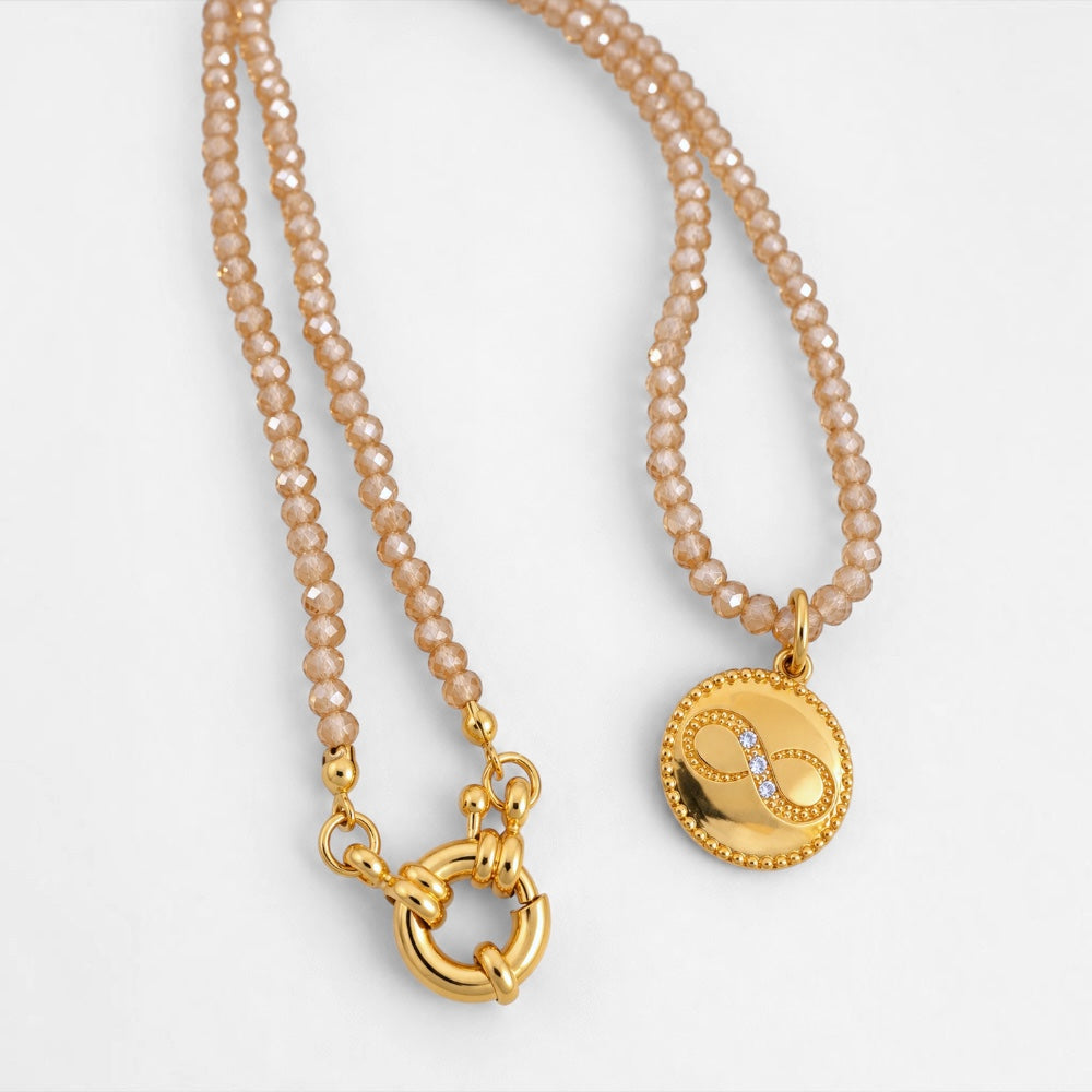 Faceted cream jade bead necklace with polished gold-plated round infinity pendant and circular ring clasp